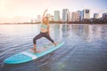 Sunrise SUP Yoga practice in Waikiki warrior pose Royalty Free Stock Photo