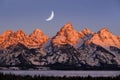 Sunrise on Teton Mountain Range in Wyoming Alpen Glow Orange and Pink on Rugged Mountains with Crescent Moon Royalty Free Stock Photo