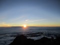 Sunrise at the top of Mount Rinjani in Lombok Island, Indonesia. View of crater lake covered in clouds from the summit. Beautiful