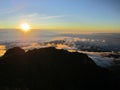 Sunrise at the top of Mount Rinjani in Lombok Island, Indonesia. View of crater lake covered in clouds from the summit. Beautiful