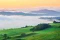 Sunrise, town and mountains in the fog, beautiful landscape Royalty Free Stock Photo