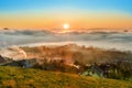 Sunrise, town and mountains in the fog, beautiful landscape Royalty Free Stock Photo