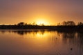 Sunrise with trees silhuet reflecting in the water Royalty Free Stock Photo