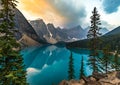 Sunrise with turquoise waters of the Moraine lake with sin lit rocky mountains in Banff National Park of Canada in Royalty Free Stock Photo