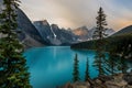 Sunrise with turquoise waters of the Moraine lake with sin lit rocky mountains in Banff National Park of Canada in Royalty Free Stock Photo