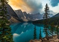 Sunrise with turquoise waters of the Moraine lake with sin lit rocky mountains in Banff National Park of Canada in Royalty Free Stock Photo