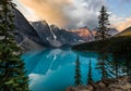 Sunrise with turquoise waters of the Moraine lake with sin lit rocky mountains in Banff National Park of Canada in