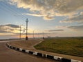 sunrise view behind heavy clouds on the Mediterranean sea meeting road , pavement and garden Royalty Free Stock Photo