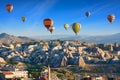 Colorful hot air balloons fly in blue sky over amazing rocky valley in Cappadocia, Turkey Royalty Free Stock Photo