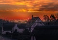 Sunrise in the village of Monkton, Kent, UK. The sun is just appearing behind a cloud producing a rim light and misty haze