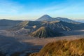 Sunrise in volcanic caldera in Bromo Tengger Semeru National Park. Morning sun rays illuminate the peaks of volcanoes and crater Royalty Free Stock Photo