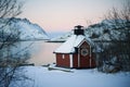 Sunrise, winter, unfrozen water, snow-capped mountains, red house and reflection of the pink sky, Royalty Free Stock Photo