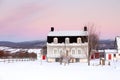 Sunrise winter view of beautiful patrimonial brick country house with metal Mansard roof and dormer windows