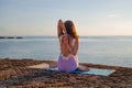 Sunrise yoga practice. Young woman practicing Gomukhasana, Cow Face Pose, seated asana in hatha yoga. View from back. Bali, Royalty Free Stock Photo
