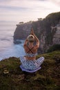 Sunrise yoga practice. Young woman practicing Padmasana, Lotus Pose. Seated asana. Hands raised up in namaste mudra. Self-care