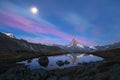 Sunrise in Zermatt with the Matterhorn mountain reflecting in lake Stellisee and the moon setting Royalty Free Stock Photo