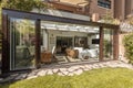 Sunroom with wide open sliding doors with wooden and wicker Royalty Free Stock Photo