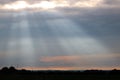 Suns rays through dark clouds.