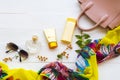 Sunscreen ,body lotion ,perfume ,sunglasses ,yellow scarf and pink hand bag of beauty health care