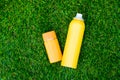 Sunscreen body spray and sunscreen facial lotion on green grass