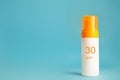 Sunscreen bottle with spf 30 cream or lotion on the aqua blue background with copy space. Sun protection, sunblock, uv cosmetic Royalty Free Stock Photo