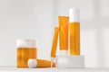 Sunscreen bottles on podium 3d render. Skincare lotion, beauty cosmetic cream, mockup of blank orange tubes and jars