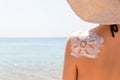 Sunscreen lotion in sun shape on tanned woman`s shoulder Royalty Free Stock Photo