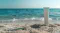 Sunscreen lotion tube on sandy beach, ocean in background with empty space. Summer skin protection concept, sunblock Royalty Free Stock Photo