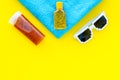 Sunscreen for sea vacation. Bottles with cream or lotion near sea shells, sunglasses, towel on yellow background top Royalty Free Stock Photo