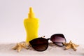 Sunscreen spray bottle and summer straw hat beach shoes and sunglasses against white copy space. Summer vacation banner Royalty Free Stock Photo