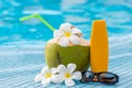 Sunscreen, sunglasses and green coconut with beautiful flowers o Royalty Free Stock Photo