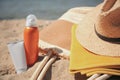 Sunscreens, straw hat, bag and towel on beach, closeup. Sun protection care Royalty Free Stock Photo