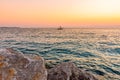 Sunset above the boat on Adriatic sea. Magic soft light and blue water near the Piran city, Slovenia. Stone rock in foreground Royalty Free Stock Photo