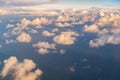 Sunset above fluffy clouds from an airplane window with sunlight. Abstract nature landscape background at twilight time Royalty Free Stock Photo