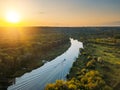 Sunset above forest river, aerial view from drone