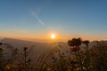 Sunset above horizon line with sun setting down behind mountains Royalty Free Stock Photo