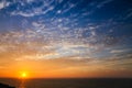 Sunset above the sea landscape panorama with full yellow sun reflections over the Atlantic Ocean and beautiful blue sky with white