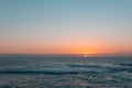 Sunset above sea or ocean. Wavy surface of water. Horizon line