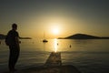 Man with bag on back standing in sunset at Adriatic Sea in Croatia Royalty Free Stock Photo