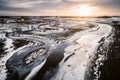 Sunset aerial view of two rivers with cracked ice in winter time