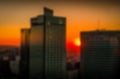 Sunset against the backdrop of skyscrapers. Evening landscape of the big city. Blurred background in warm colors