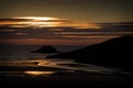 Sunset along coast at Porth Beach, Cornwall, England