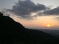 Sunset at the amazon rainforest, showing the silhouttes of the tree canopy following the contours of the hills