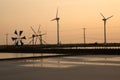 Sunset at ancient and new wind mill use for move the sea water i Royalty Free Stock Photo