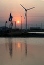 Sunset at ancient and new wind mill use for move the sea water i Royalty Free Stock Photo