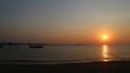 Sunset approaching the night, boat silhouette on the beach