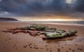 Sunset on the Atlantic coast overlooking a huge beautiful boulder under storm clouds