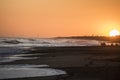 Sunset at atlantic ocean beach with windy land at the end of beautiful day Royalty Free Stock Photo