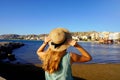 Sunset back view of girl holding straw hat in Crotone city on Calabria coast, Italy Royalty Free Stock Photo