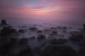 Sunset background on a beach with breakwater objects, dreamland nuance